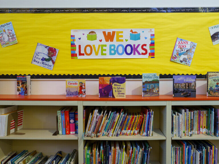 Books displayed on shelves and a bulletin board in a school library.