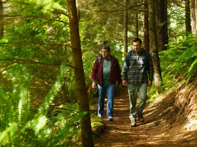 Two men hike a section of Amanda's trail in dappled light