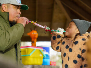 A father and daughter play together at a family party.